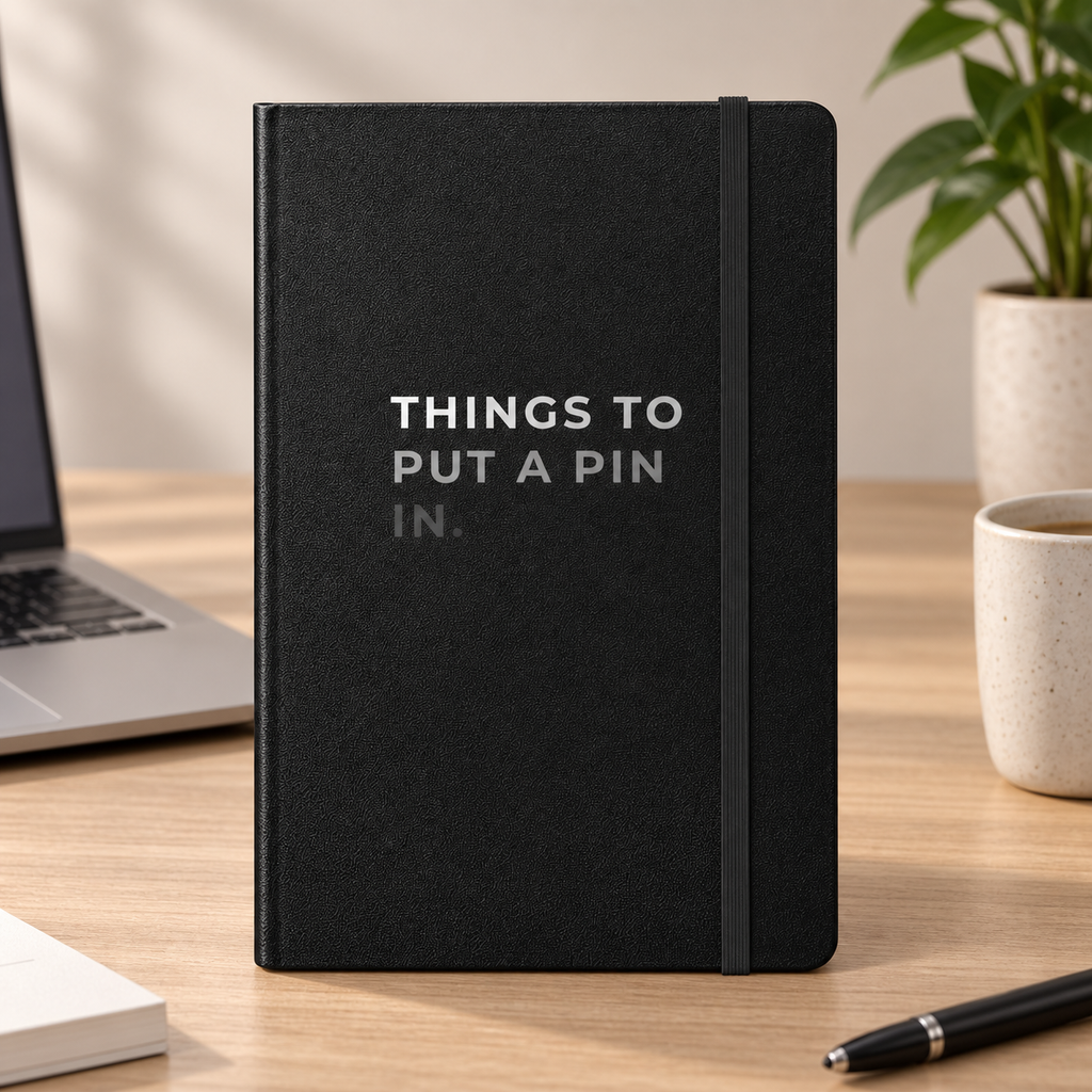 Things to Put a Pin In Hardcover Notebook — on a desk