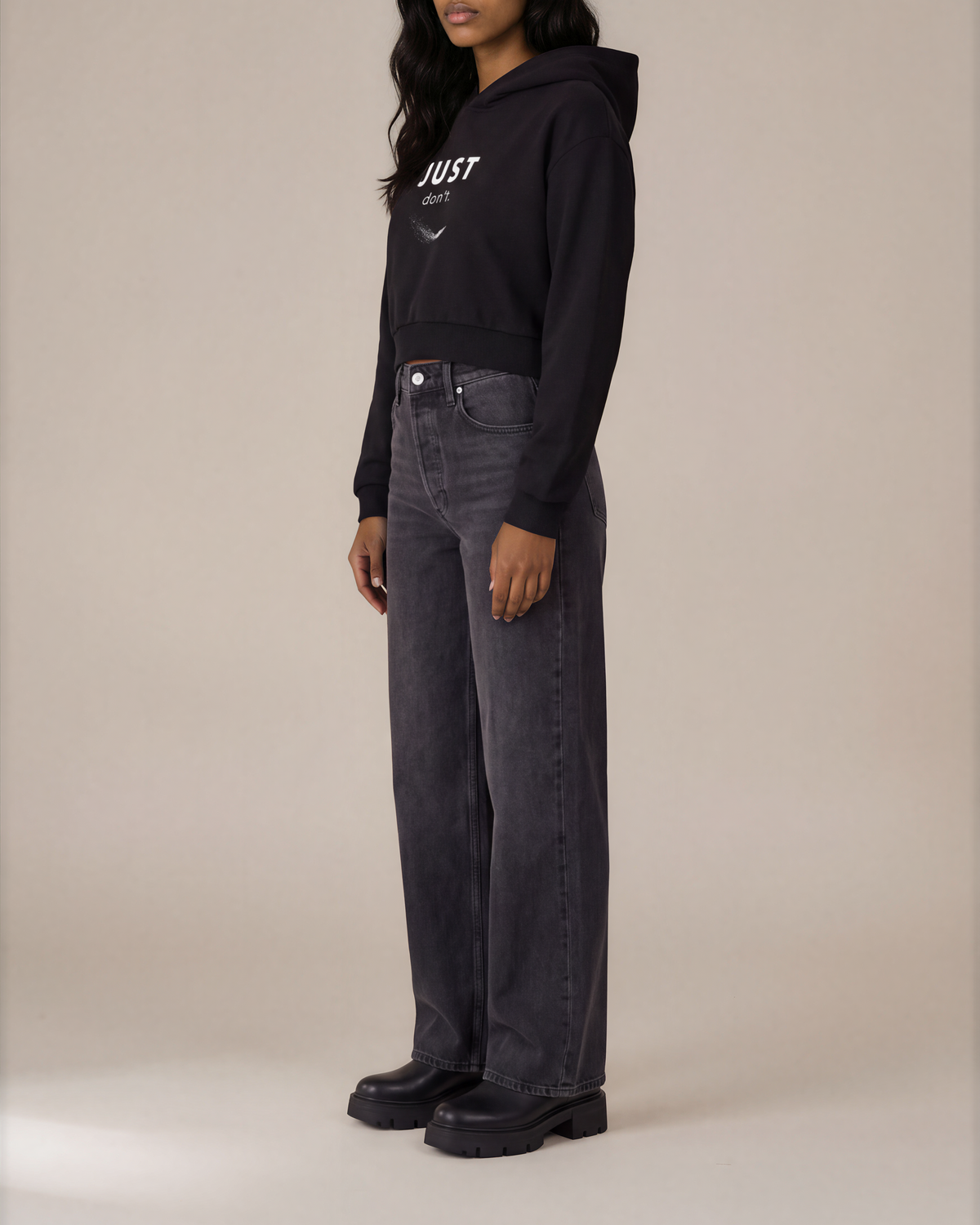 Model wearing the black Just Don’t Women’s Cropped Hoodie, side view showing cropped length