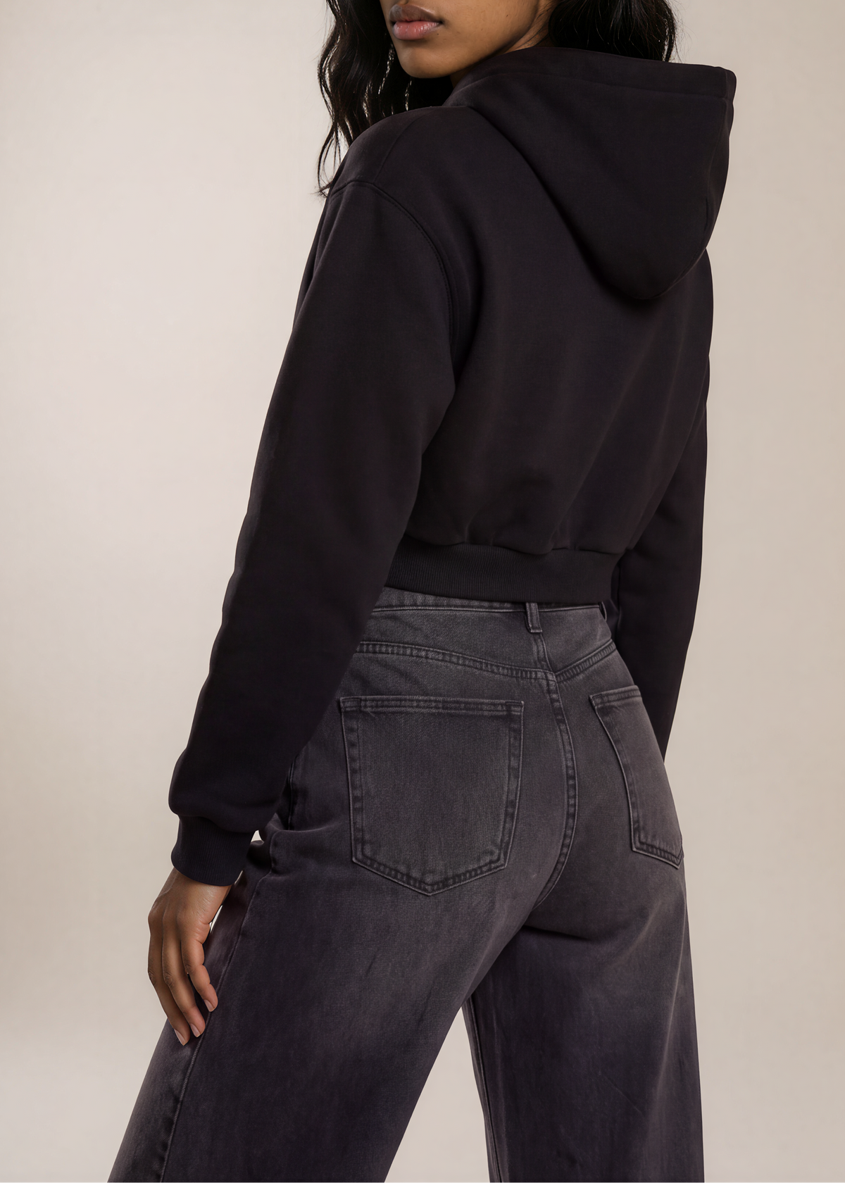 Model wearing the black Just Don’t Women’s Cropped Hoodie, plain back and hood view